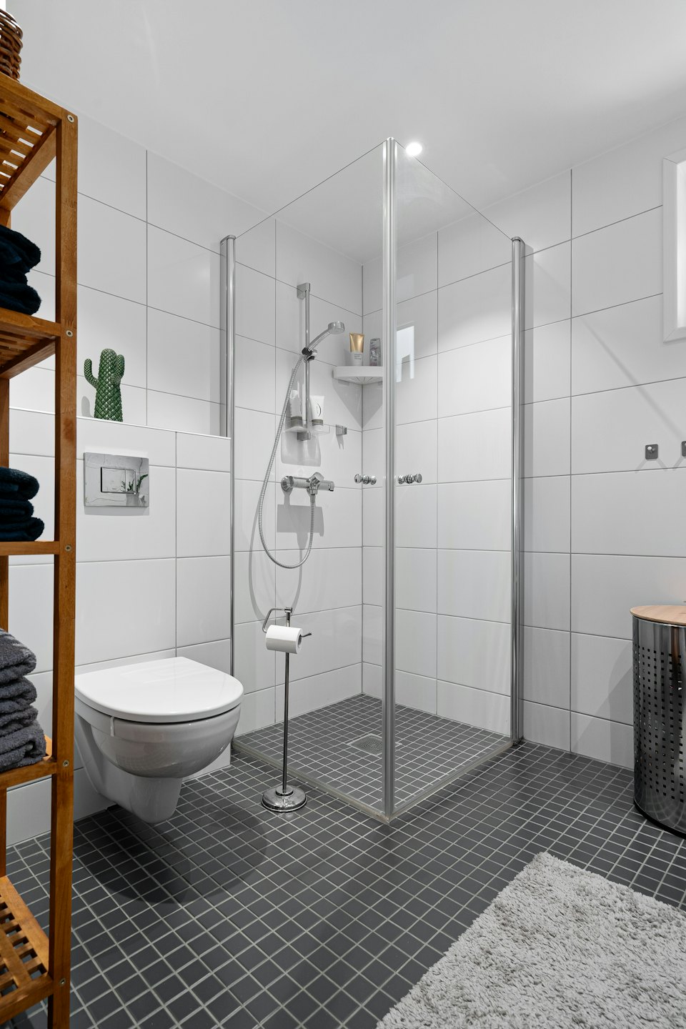 Modern bathroom with a shower and neatly stacked towels.