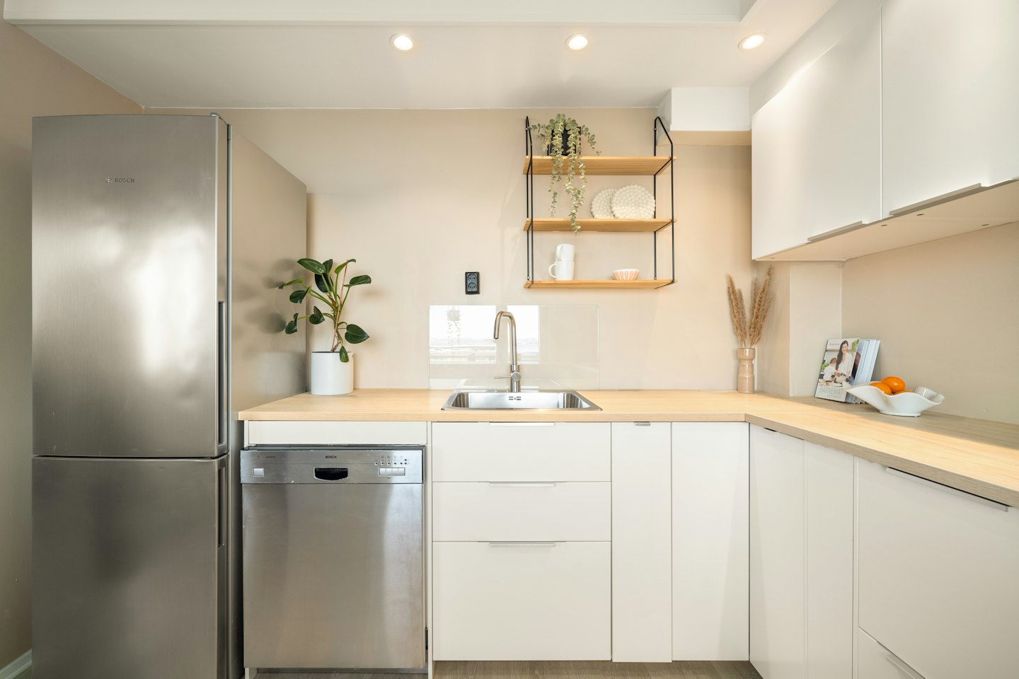 Modern kitchen with stainless steel appliances and light wooden countertops.